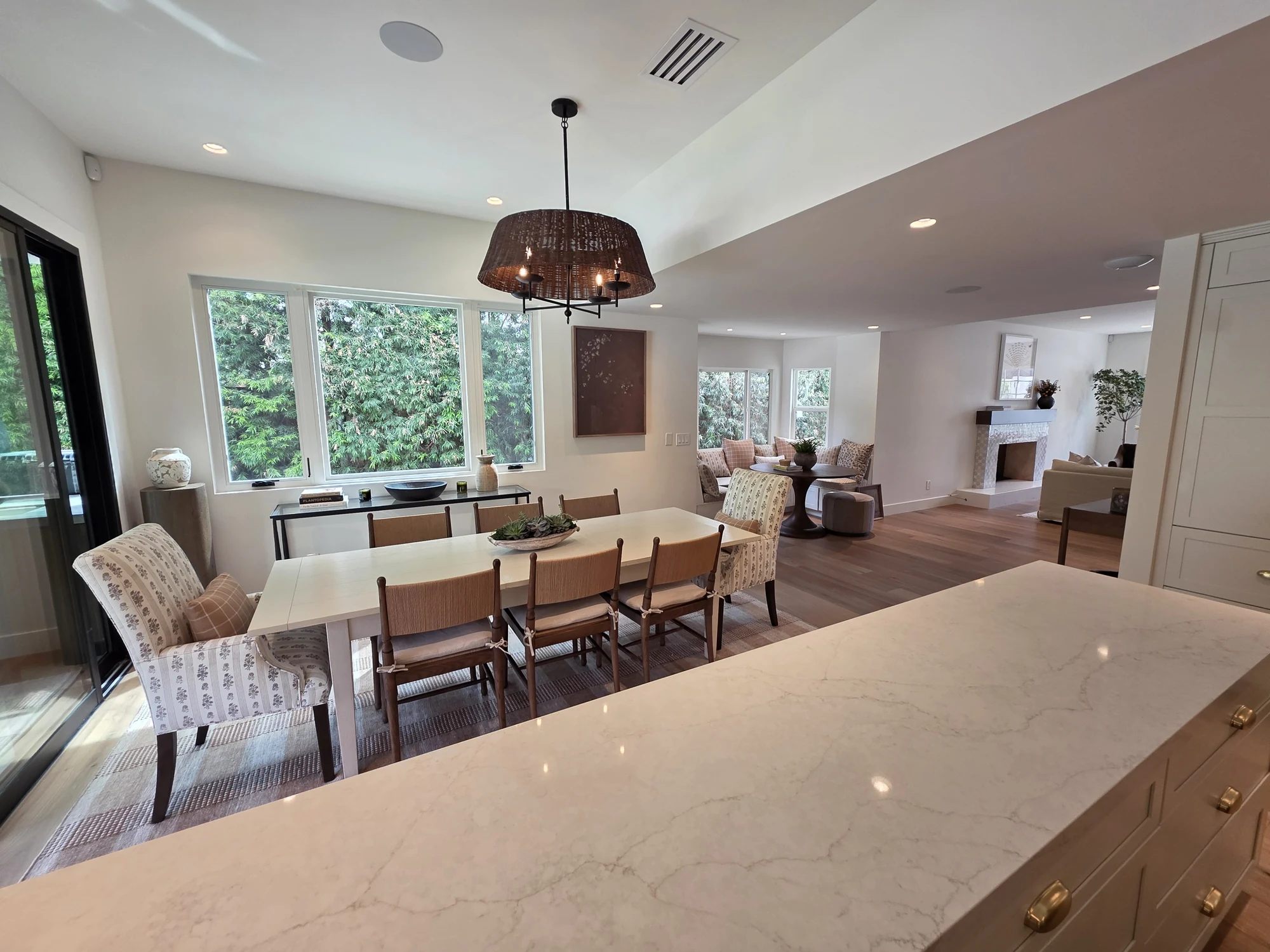 The kitchen island facing a dining area and garden windows