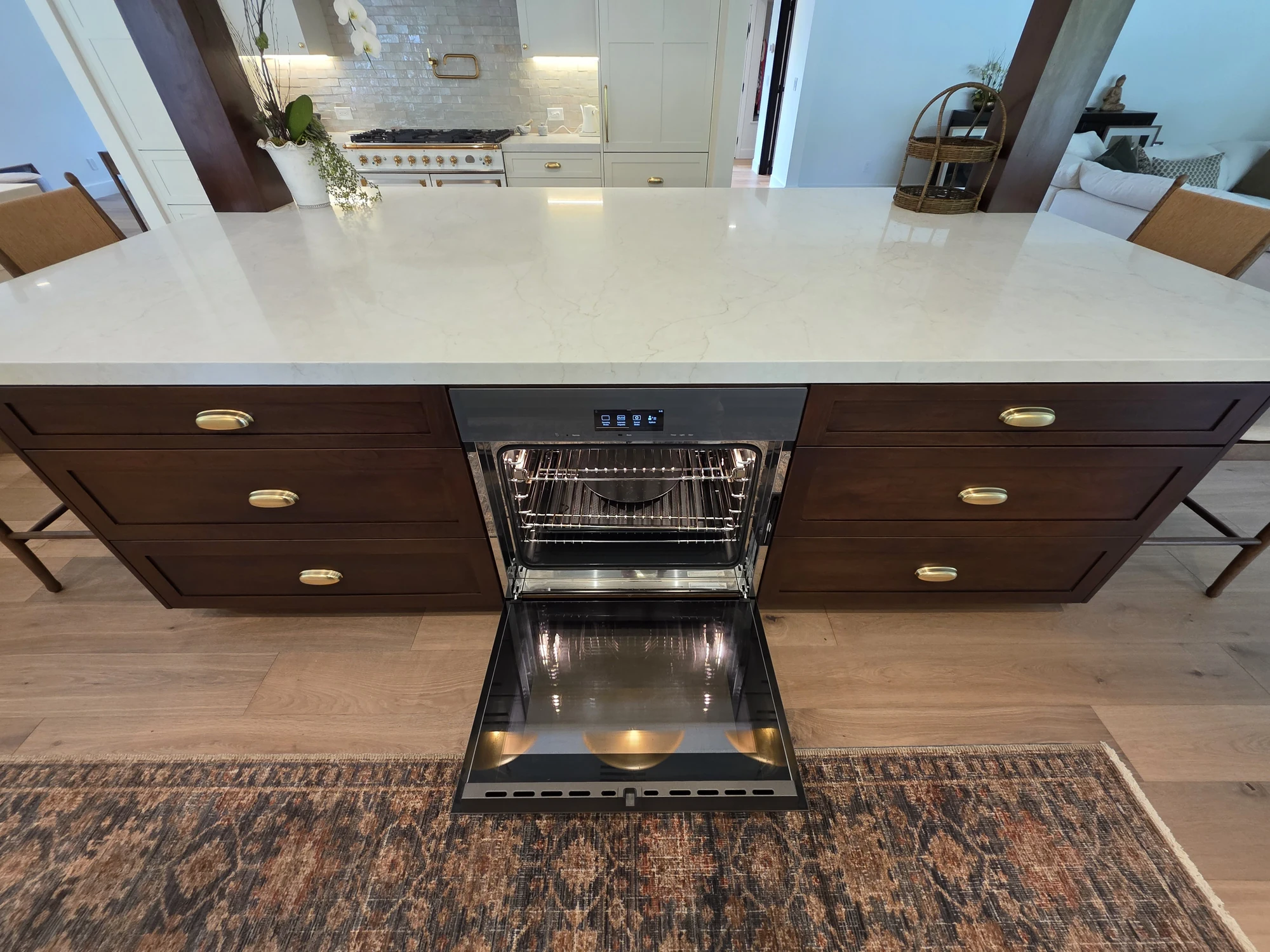 Walnut island cabinetry with an open dishwasher and integrated working surface