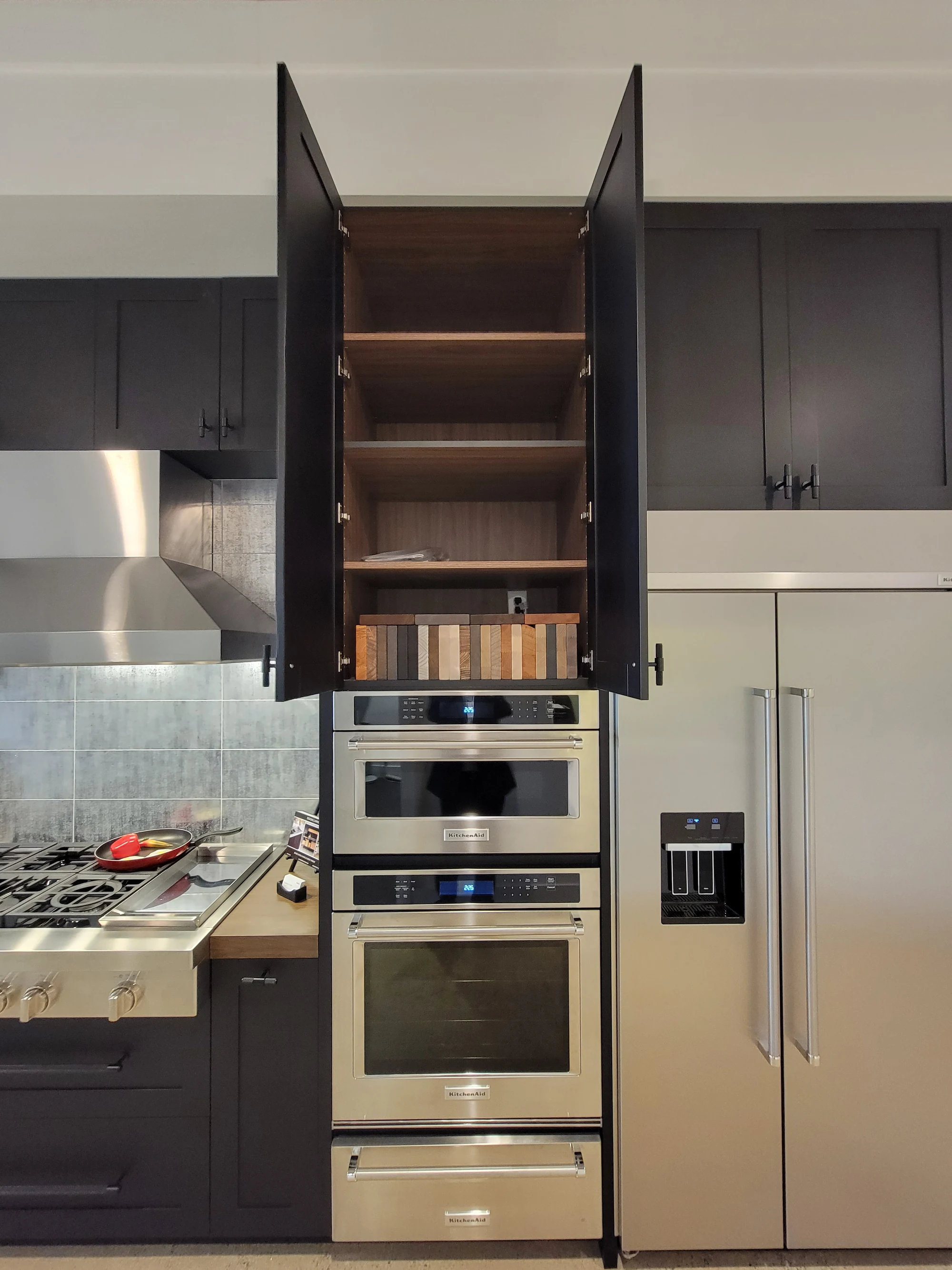 Installed appliance tower and cabinetry with an upper door open