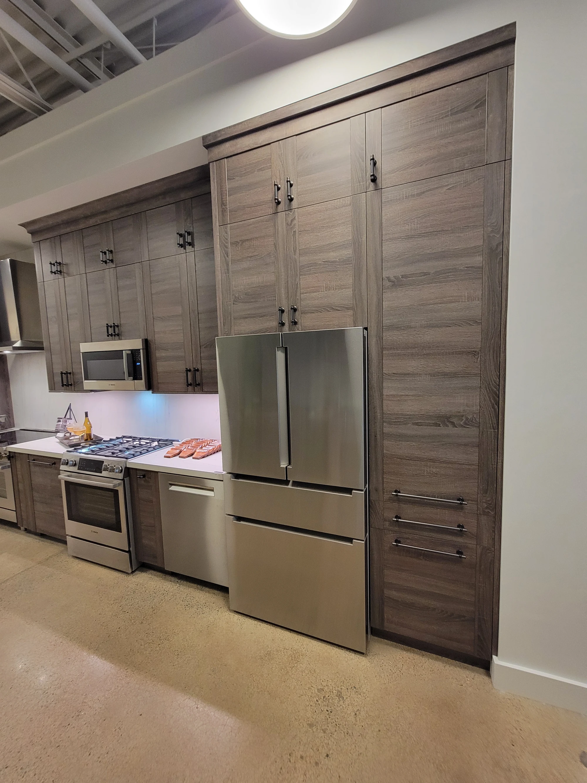 Installed timber-toned cabinetry and appliance wall in the Nashville showroom